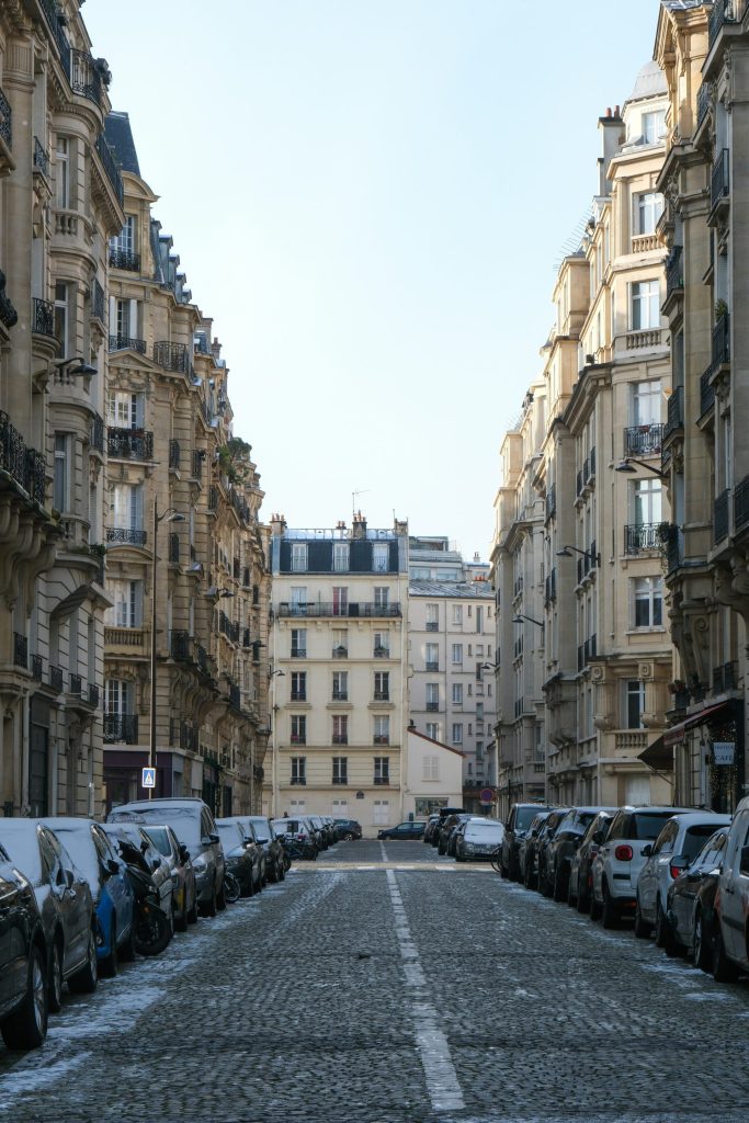a street lined with tall buildings and parked cars